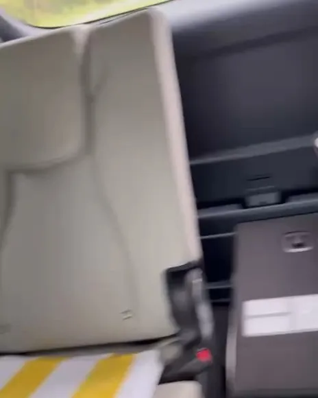 Applying sound-deadening foam inside a Toyota Prius dashboard to stop rattling noises.
