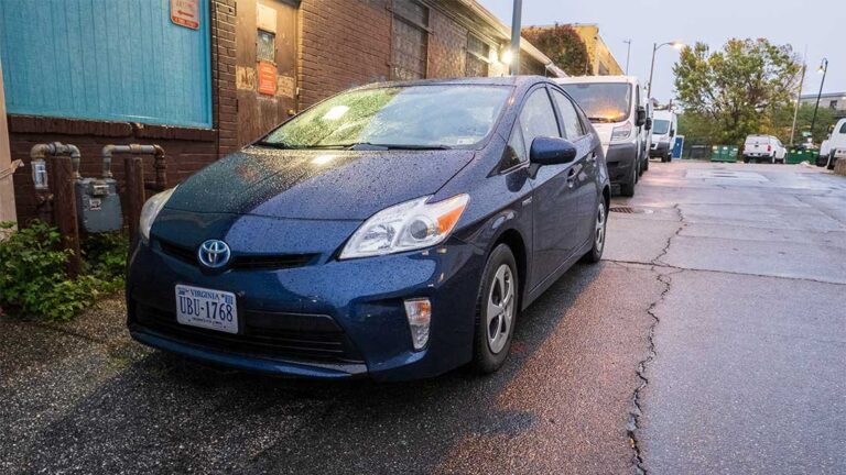 A Toyota Prius parked on a quiet suburban street at dawn.