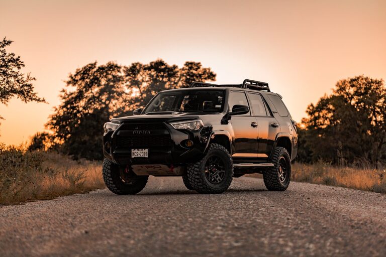 Lifted Toyota 4Runner on a dirt road with increased ground clearance and suspension components visible